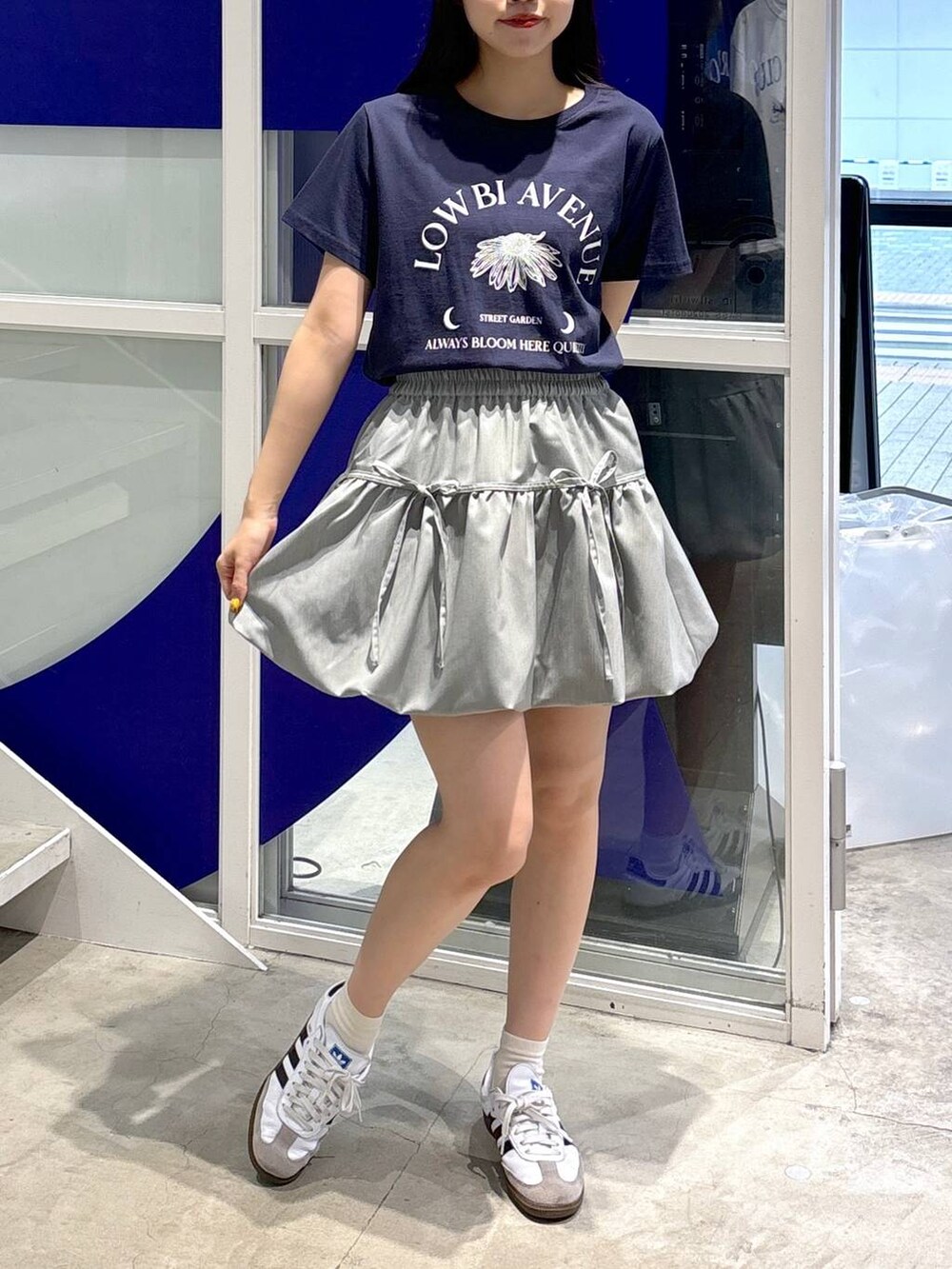 グレー系のスカート、ブルー系のTシャツ/カットソーを着用したレディースの夏コーディネートの3枚目の写真