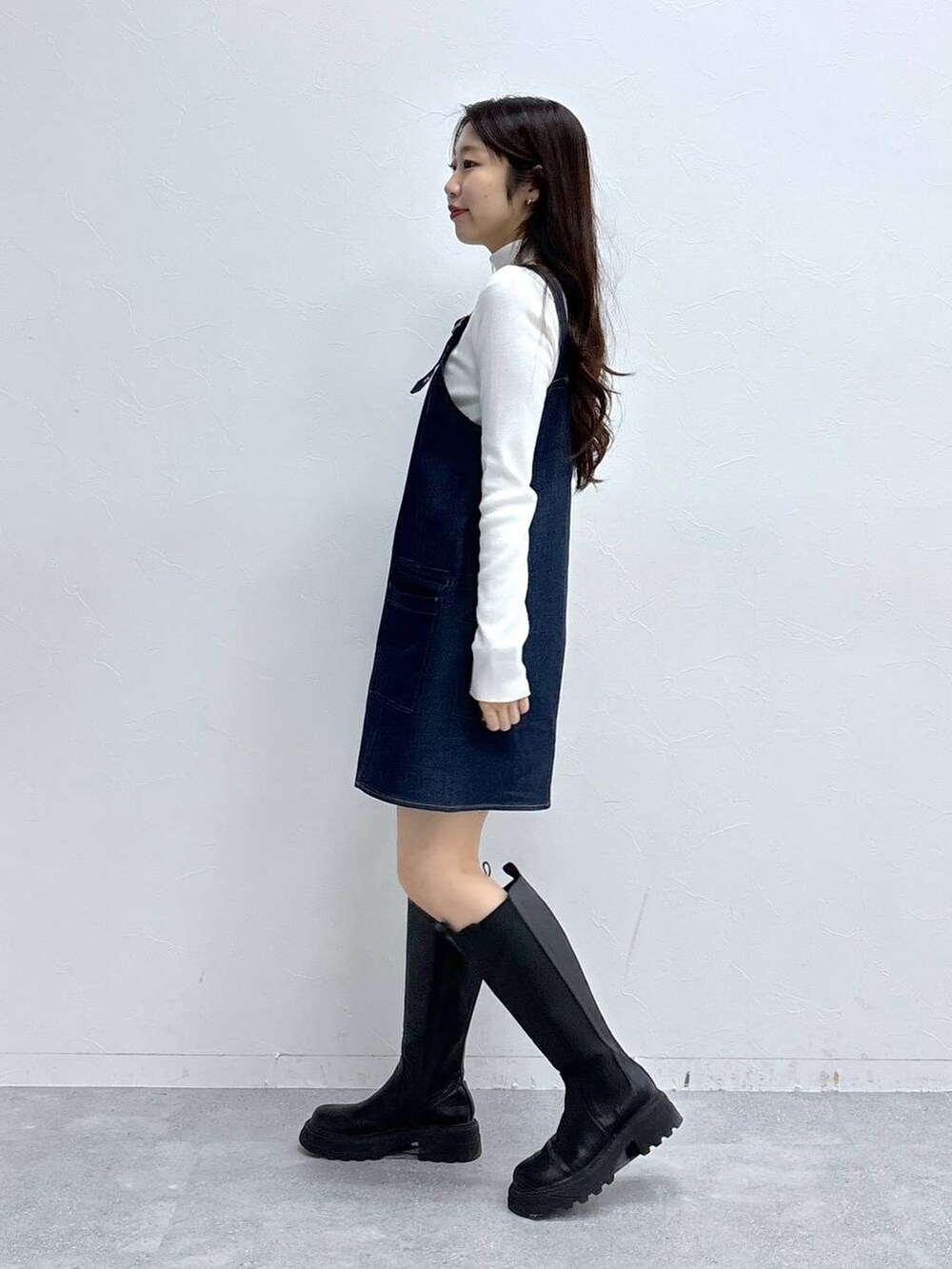 ホワイト系のニット/セーター、ブラック系のブーツを着用したレディースの冬コーディネートの3枚目の写真