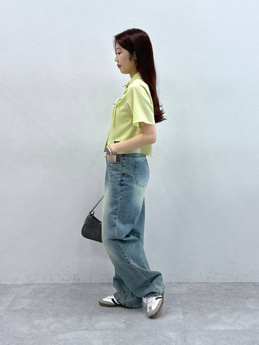 ブルー系のデニムパンツ、ブラック系のトートバッグ、グリーン系のシャツ/ブラウスを着用したレディースの夏コーディネートの3枚目の写真