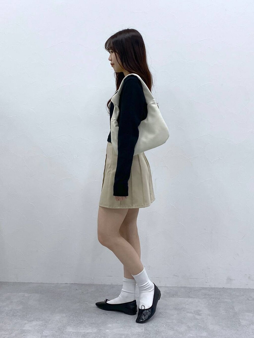 ベージュ系のスカート、ブラック系のカーディガン/ボレロを着用したレディースの春コーディネートの3枚目の写真