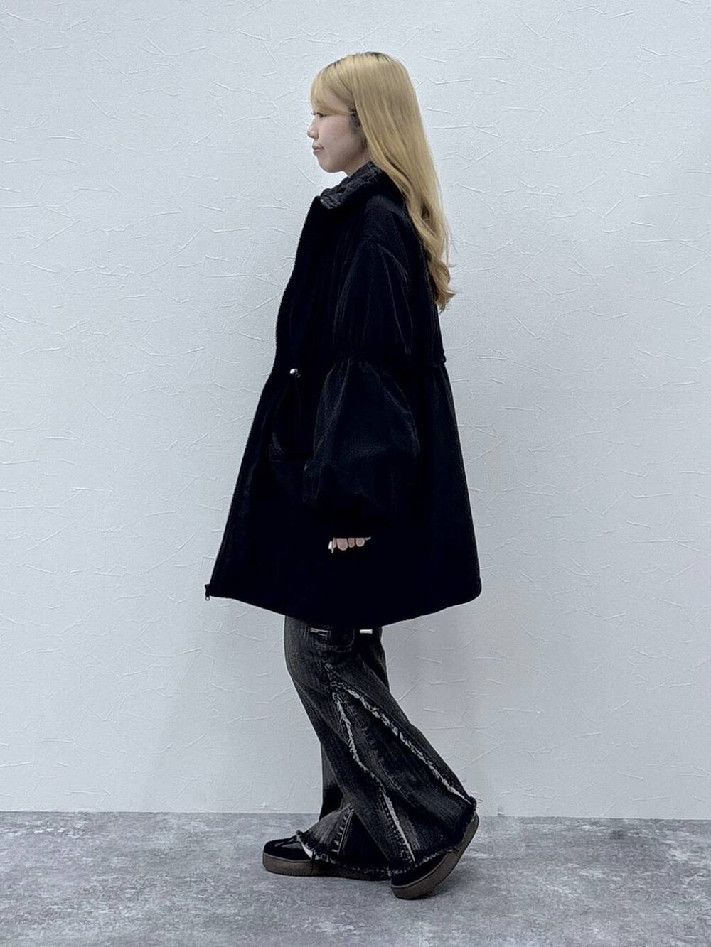 ブラック系のダウンジャケット/コート、レッド系のニット/セーター、ブラック系のデニムパンツを着用したレディースの秋コーディネートの4枚目の写真