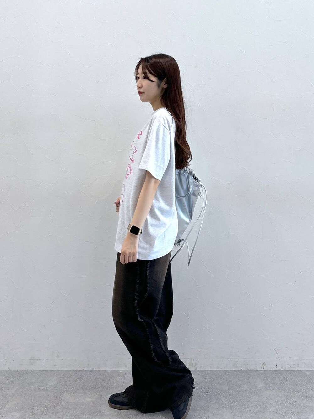 ブラック系のデニムパンツ、グレー系のTシャツ/カットソー、グレー系のバックパック/リュックを着用したレディースの夏コーディネートの3枚目の写真