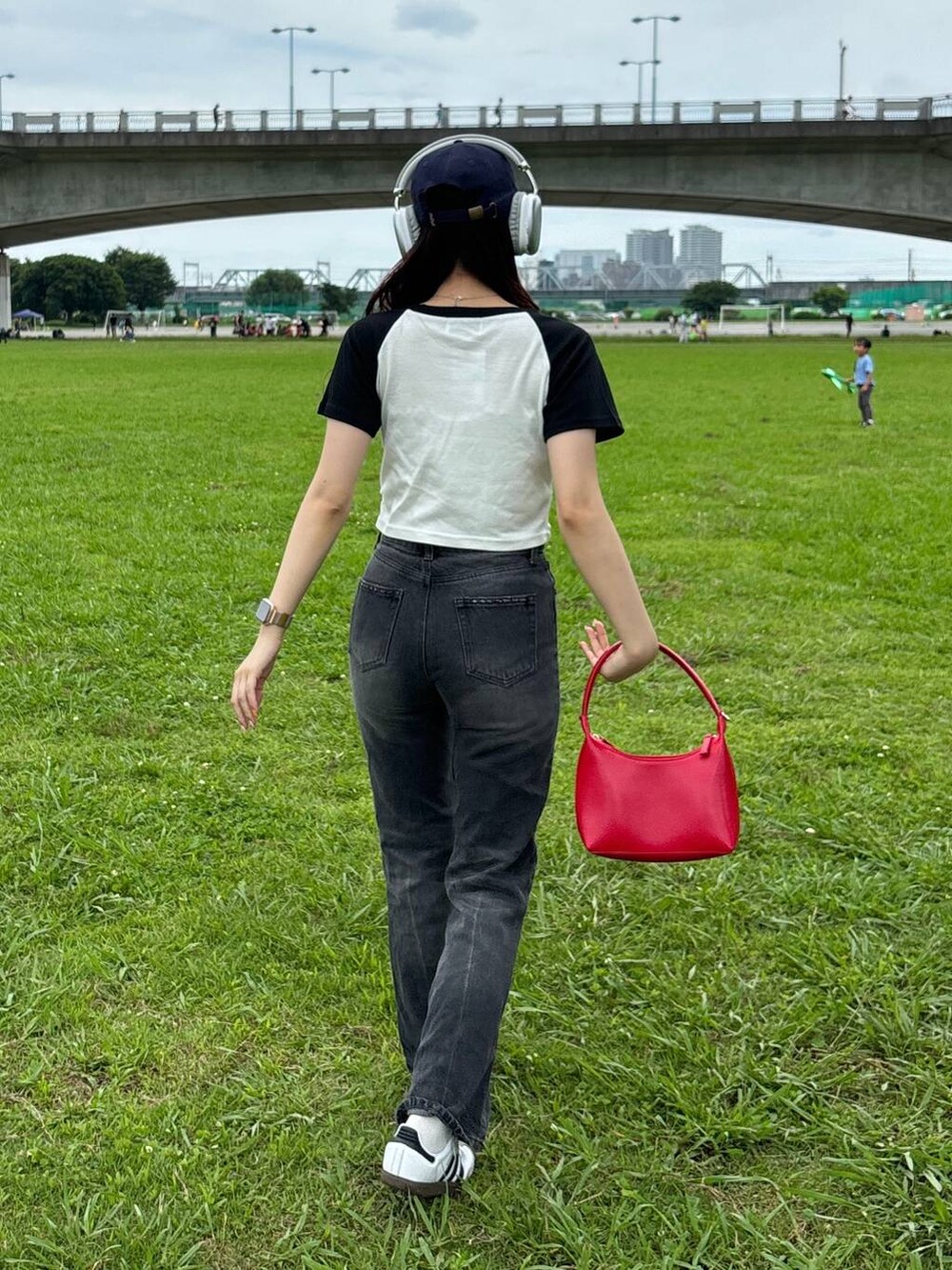 レッド系のハンドバッグ、ホワイト系のTシャツ/カットソーを着用したレディースの夏コーディネートの3枚目の写真