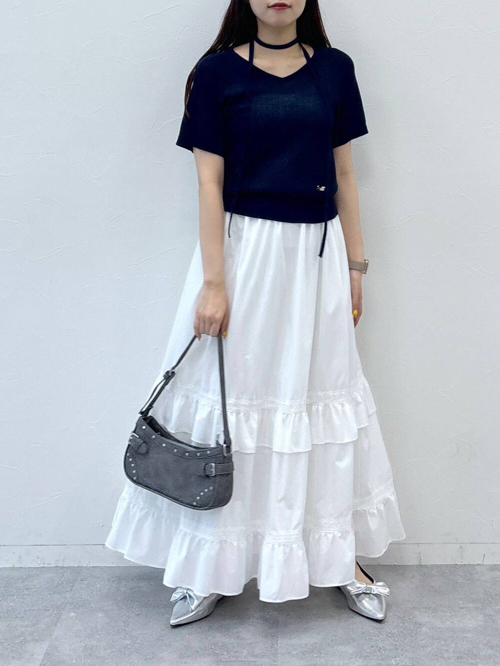 ホワイト系のスカート、ブラック系のトートバッグ、その他のサンダルを着用したレディースの夏コーディネートの3枚目の写真