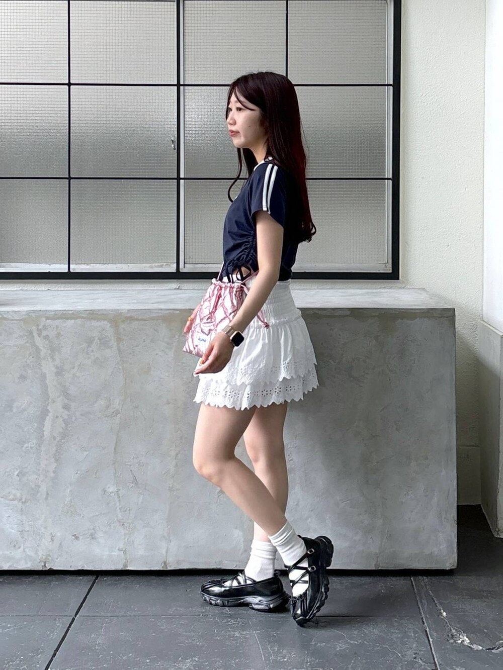 ホワイト系のスカート、ピンク系のショルダーバッグ、ブルー系のTシャツ/カットソーを着用したレディースの夏コーディネートの3枚目の写真