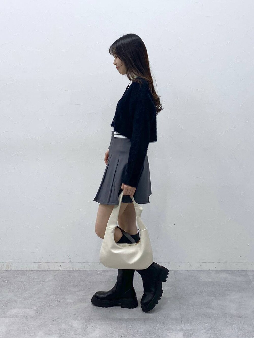 ブラック系のカーディガン/ボレロ、ベージュ系のTシャツ/カットソー、グレー系のスカートを着用したレディースの冬コーディネートの3枚目の写真