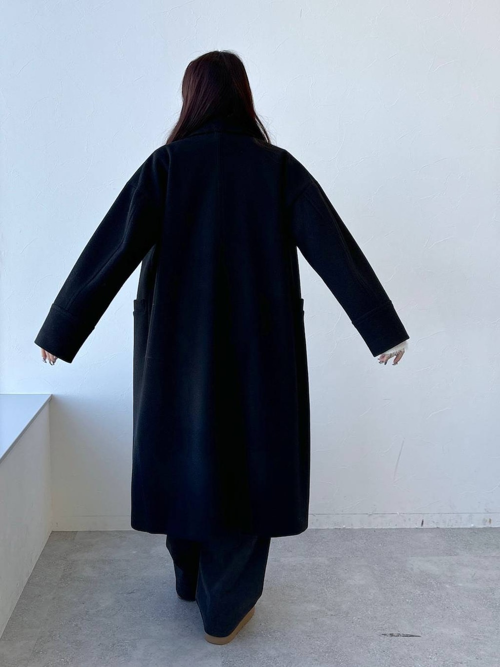 ホワイト系のTシャツ/カットソー、ブラウン系のその他パンツ、グレー系のチェスターコートを着用したレディースの冬コーディネートの4枚目の写真