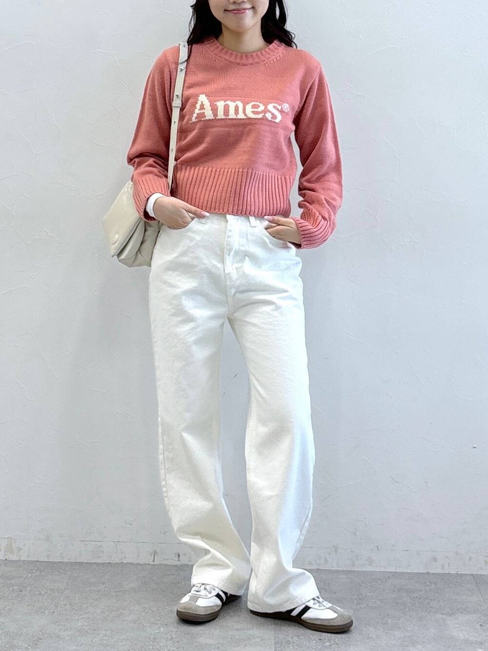 ホワイト系のハンドバッグ、ピンク系のニット/セーター、ベージュ系のその他パンツを着用したレディースの冬コーディネートの2枚目の写真