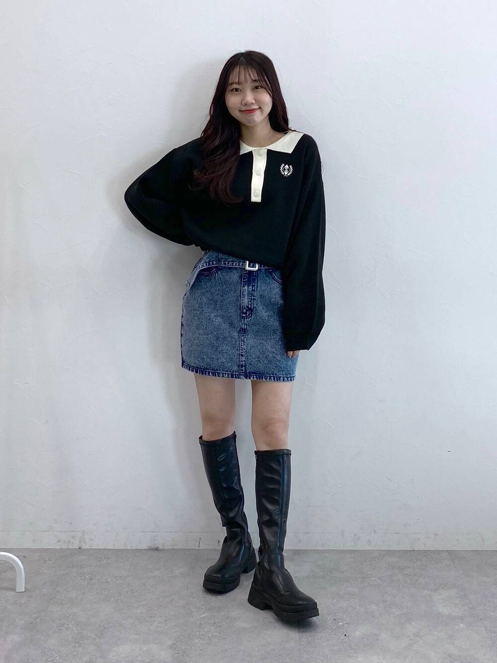 ブラック系のニット/セーター、ブルー系のデニムスカートを着用したレディースの冬コーディネートの3枚目の写真