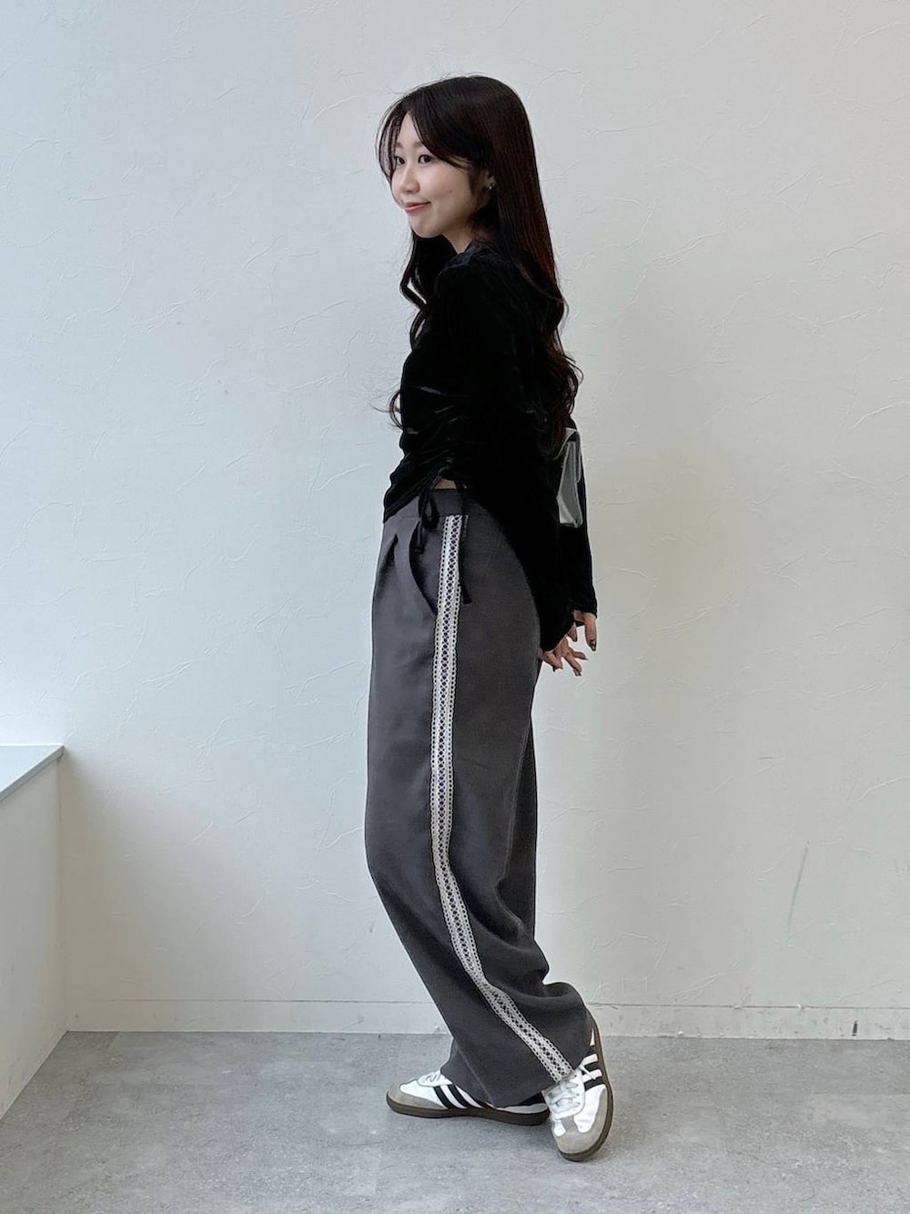 シルバー系のショルダーバッグ、グレー系のスラックス、ブラック系のTシャツ/カットソーを着用したレディースの冬コーディネートの4枚目の写真