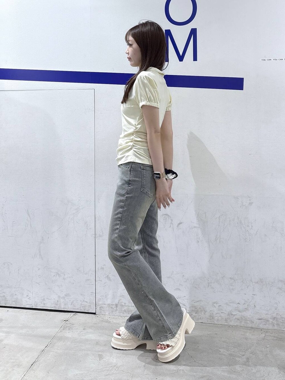 ホワイト系のサンダル、ベージュ系のTシャツ/カットソー、ブルー系のデニムパンツを着用したレディースの夏コーディネートの3枚目の写真