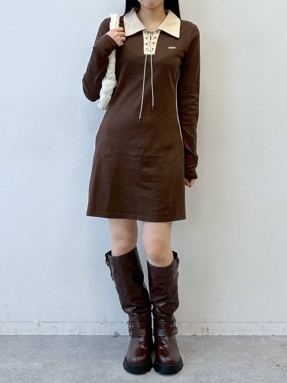 ホワイト系のショルダーバッグ、ブラウン系のブーツ、ブラウン系のワンピースを着用したレディースの冬コーディネートの2枚目の写真