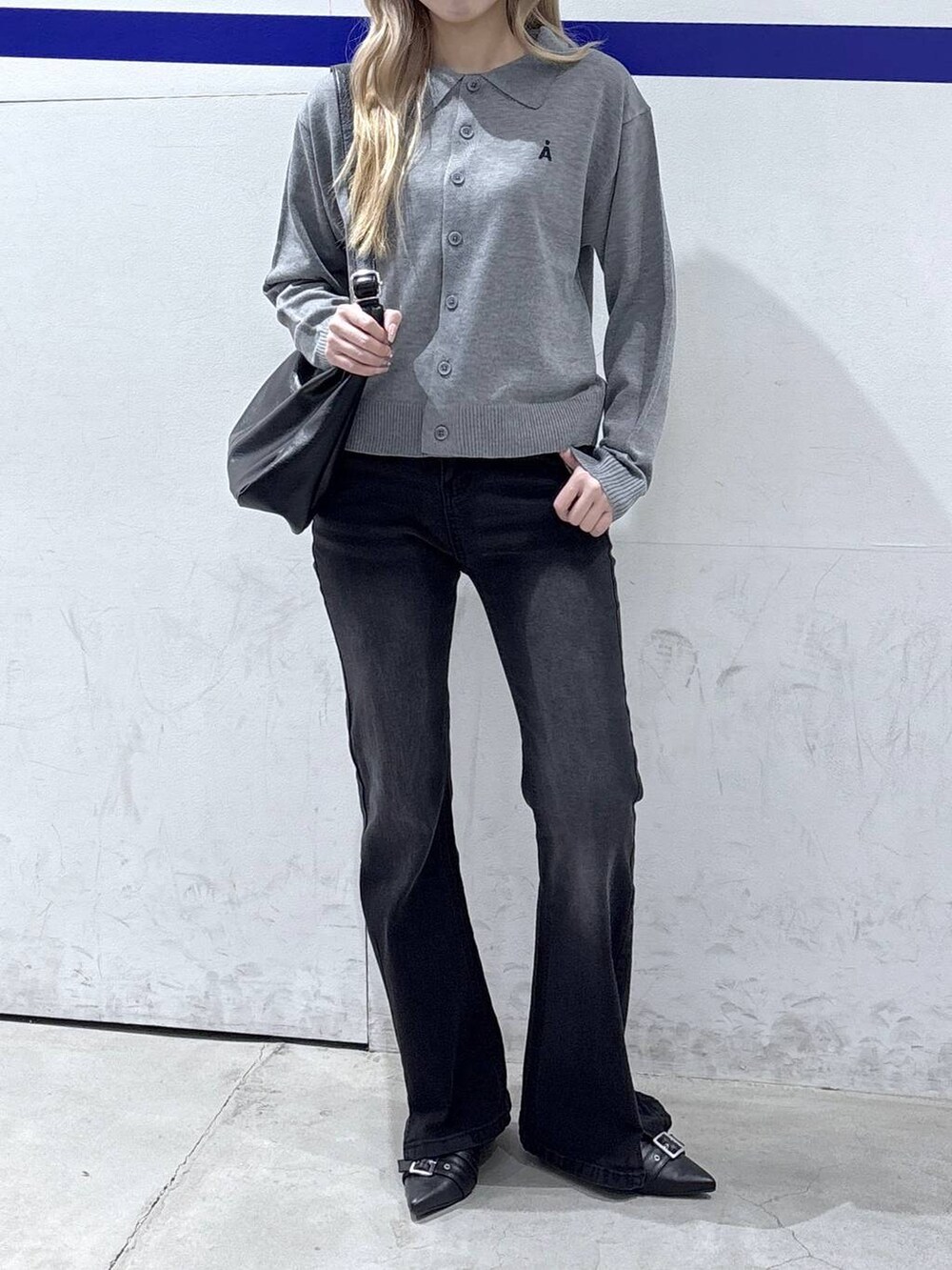 ブラック系のショルダーバッグ、ブラック系のデニムパンツ、ブラック系のパンプスを着用したレディースの冬コーディネートの2枚目の写真