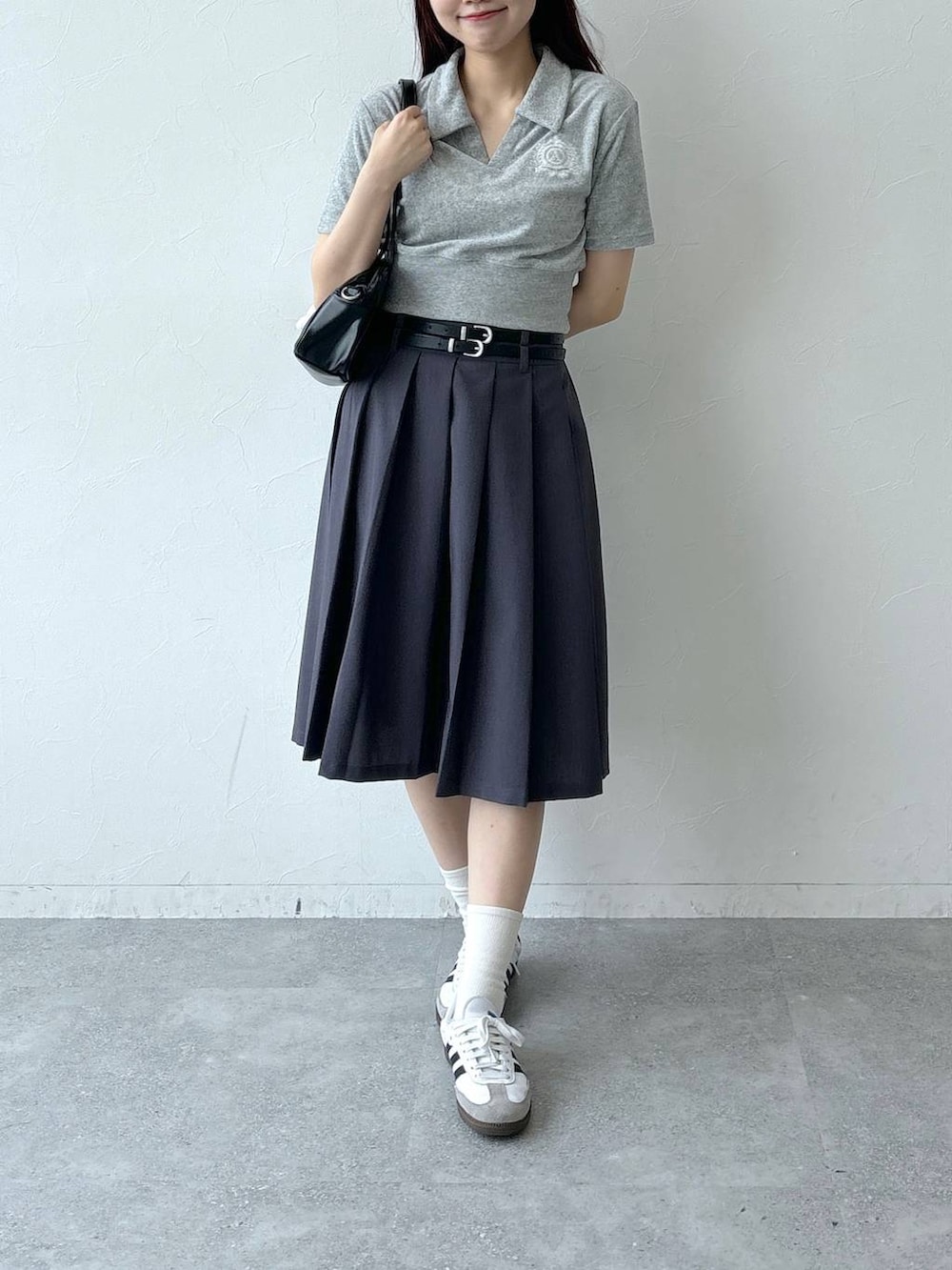 ブラック系のハンドバッグ、グレー系のスカート、グレー系のTシャツ/カットソーを着用したレディースの夏コーディネートの2枚目の写真