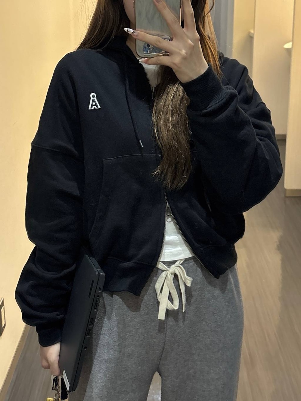 ブラック系のパーカーを着用したレディースの春コーディネートの2枚目の写真