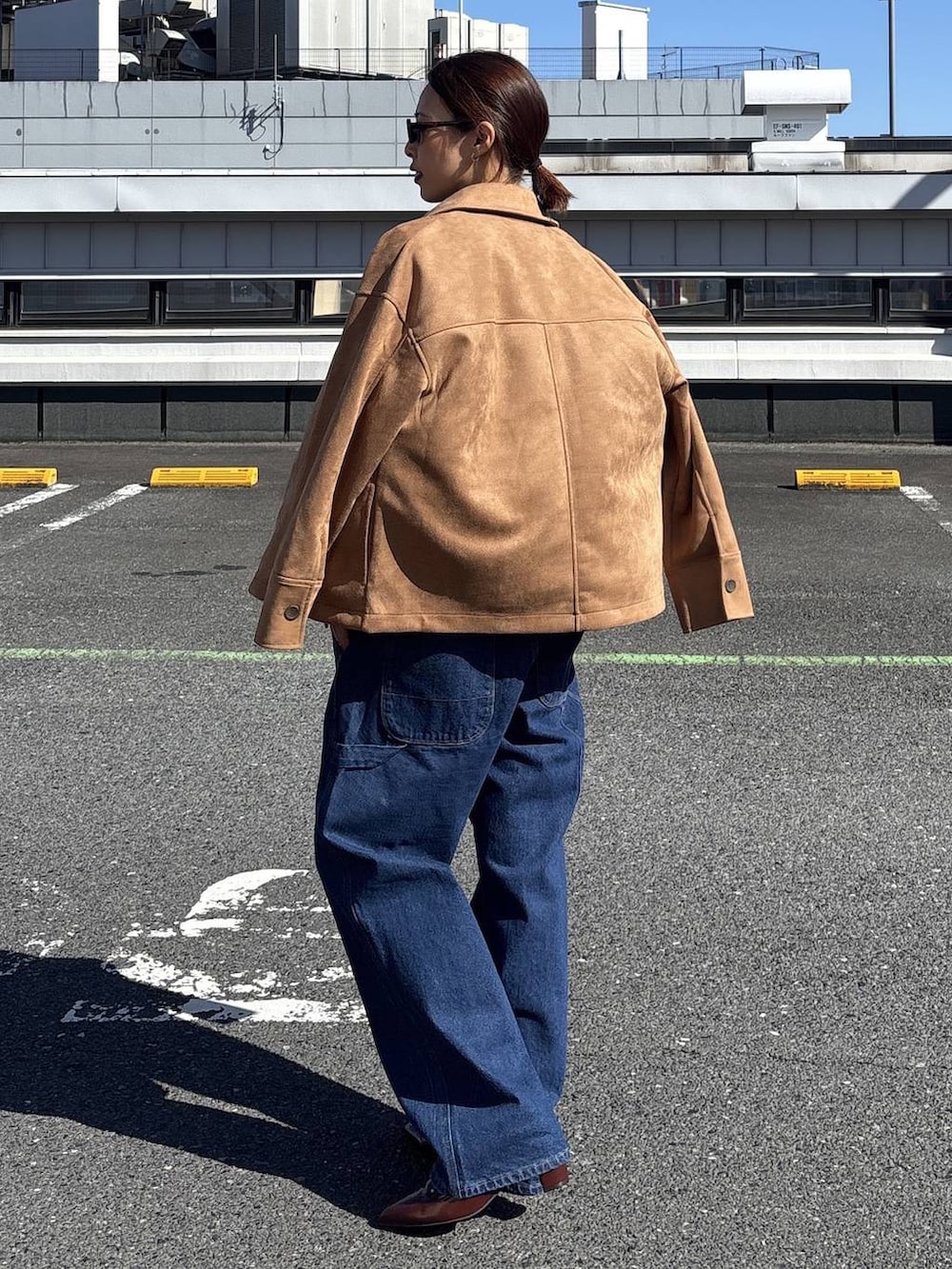 ブルー系のデニムジャケット、ブラウン系のテーラードジャケット、ブルー系のデニムパンツを着用したレディースの冬コーディネートの6枚目の写真