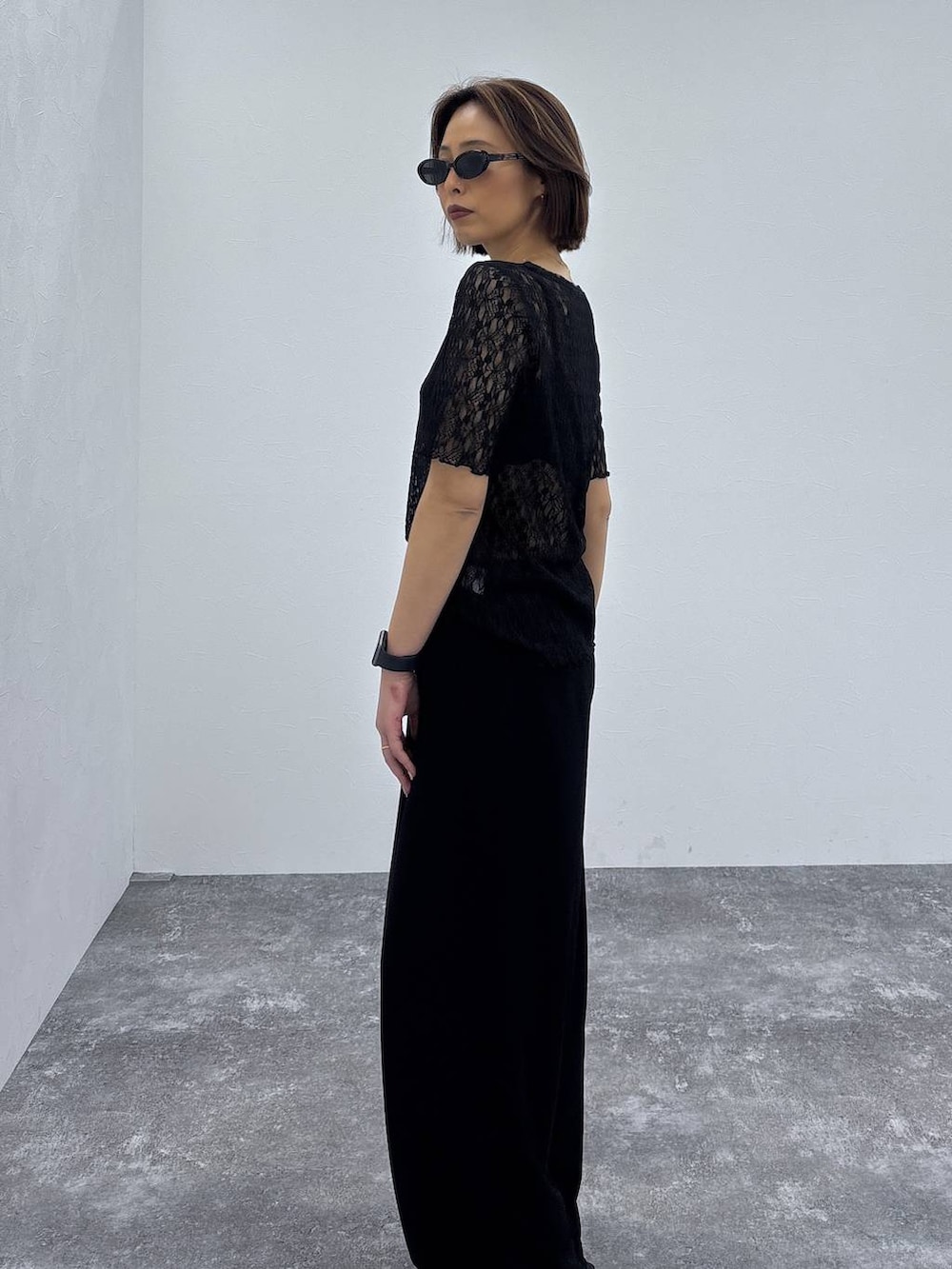 ブラック系のTシャツ/カットソー、ブラック系のパンプス、ゴールド系のネックレスを着用したレディースの春コーディネートの7枚目の写真