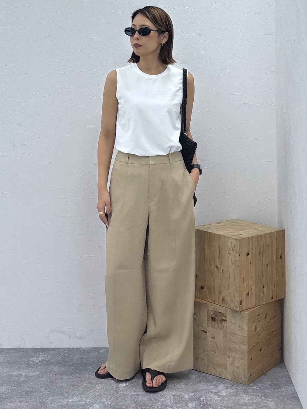 ブラック系のキャミソール、ブラック系のトートバッグ、ホワイト系のTシャツ/カットソーを着用したレディースの夏コーディネートの2枚目の写真