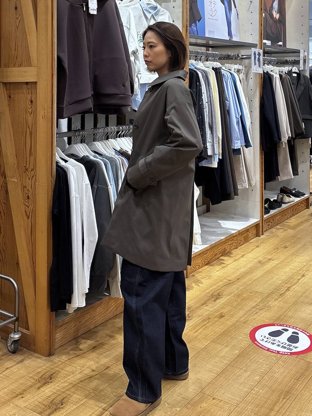 ブラウン系のステンカラーコート、ブルー系のデニムパンツを着用したレディースの冬コーディネートの6枚目の写真