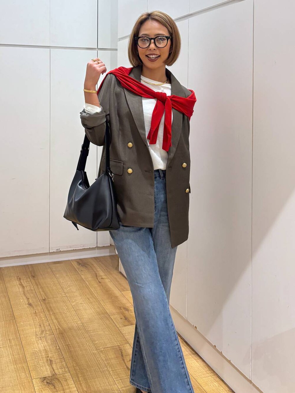 レッド系のカーディガン/ボレロ、ホワイト系のTシャツ/カットソー、ブルー系のデニムパンツを着用したレディースの秋コーディネートの6枚目の写真