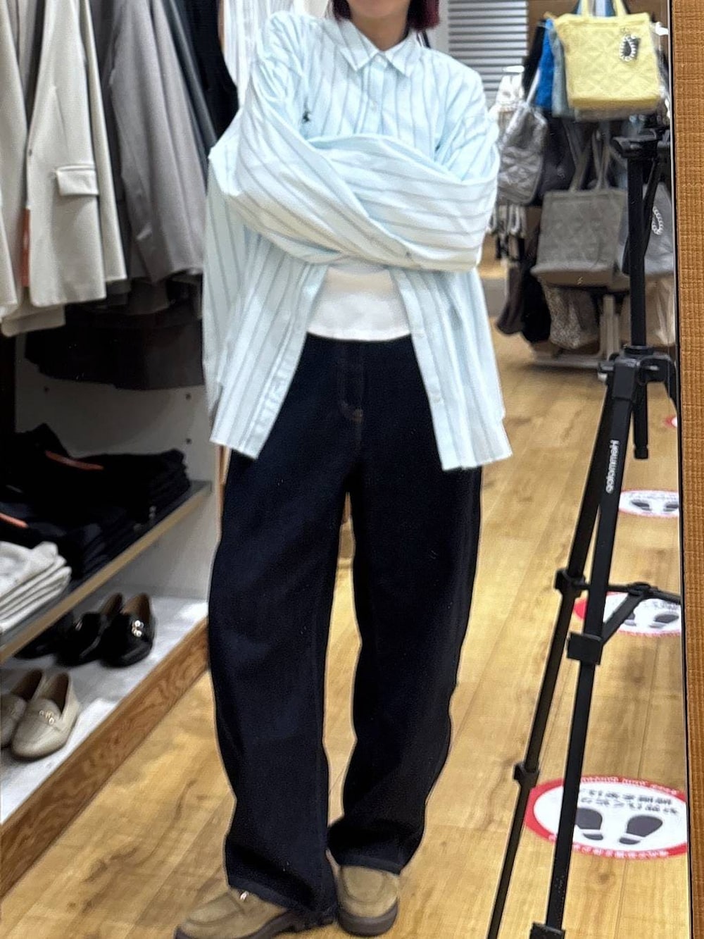 ベージュ系のローファー、ブルー系のデニムパンツを着用したレディースの春コーディネートの3枚目の写真