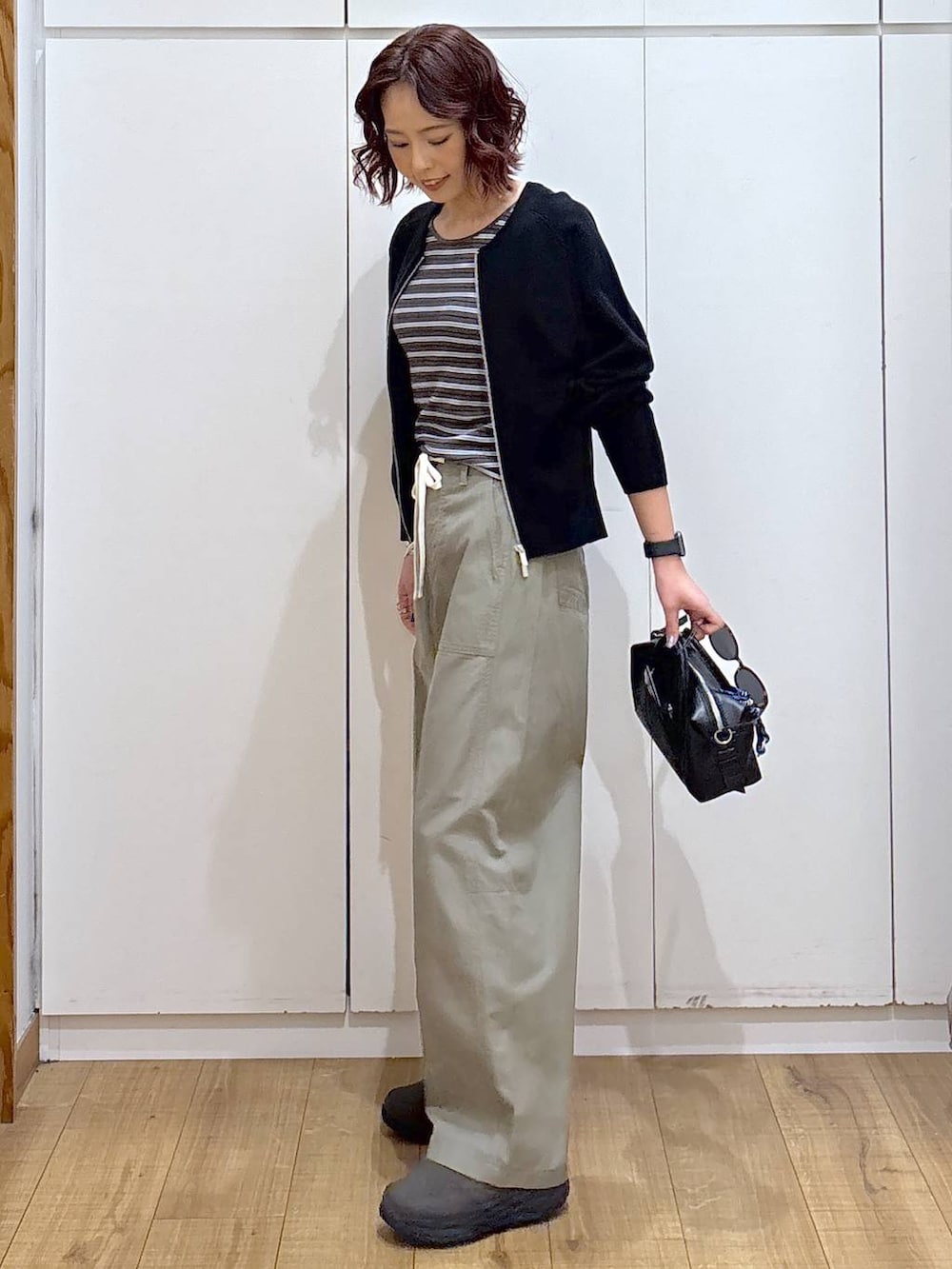 グリーン系のその他パンツ、ブラック系のカーディガン/ボレロ、ブラック系のボストンバッグを着用したレディースの春コーディネートの3枚目の写真