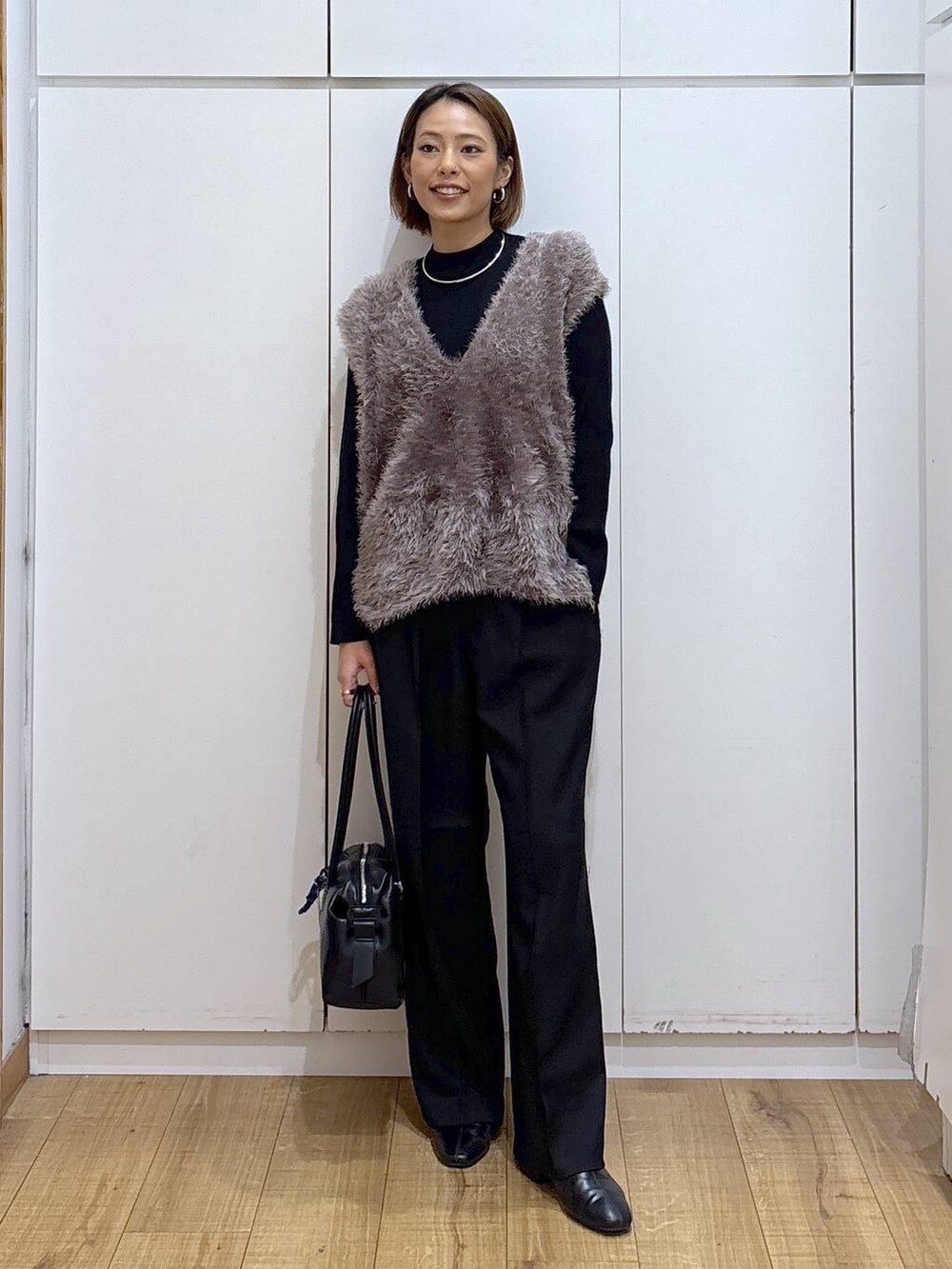 ブラック系のボストンバッグ、ブラック系のニット/セーター、ブラック系のその他パンツを着用したレディースの秋コーディネートの3枚目の写真