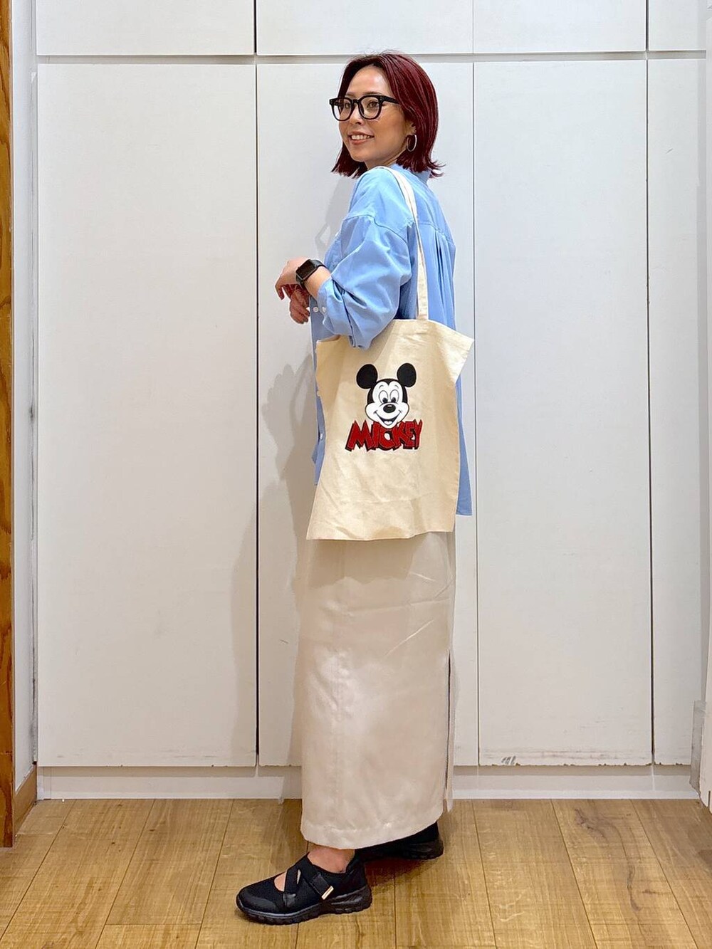 ブラック系のスニーカー、ホワイト系のTシャツ/カットソー、ブルー系のシャツ/ブラウスを着用したレディースの春コーディネートの3枚目の写真