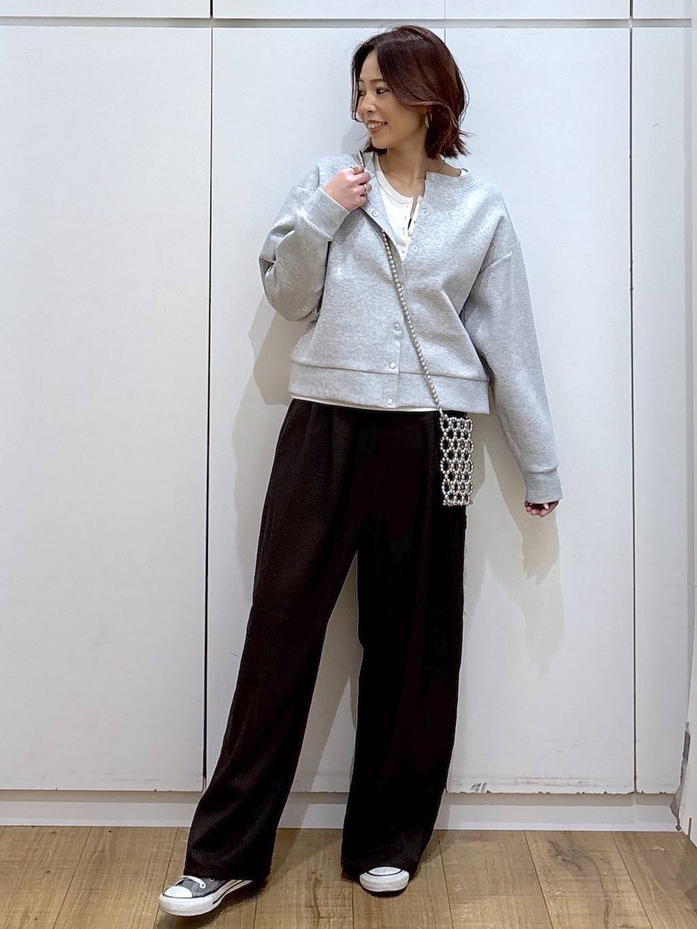 グレー系のカーディガン/ボレロ、ブラウン系のその他パンツ、ホワイト系のタンクトップを着用したレディースの春コーディネートの3枚目の写真