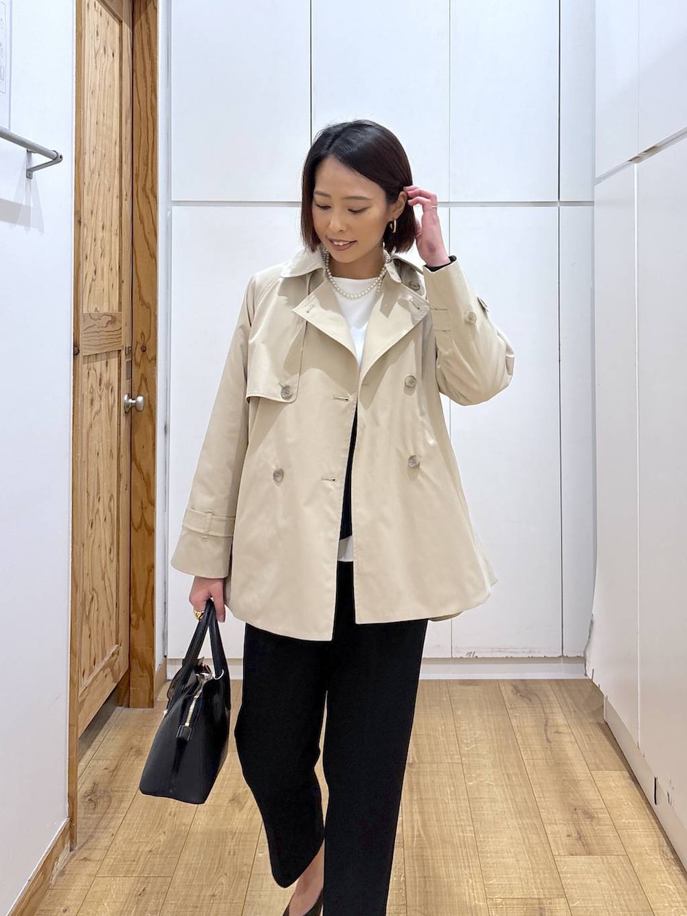 ブラック系のショルダーバッグ、ブラック系のパンプス、ブラック系のセットアップを着用したレディースの冬コーディネートの7枚目の写真