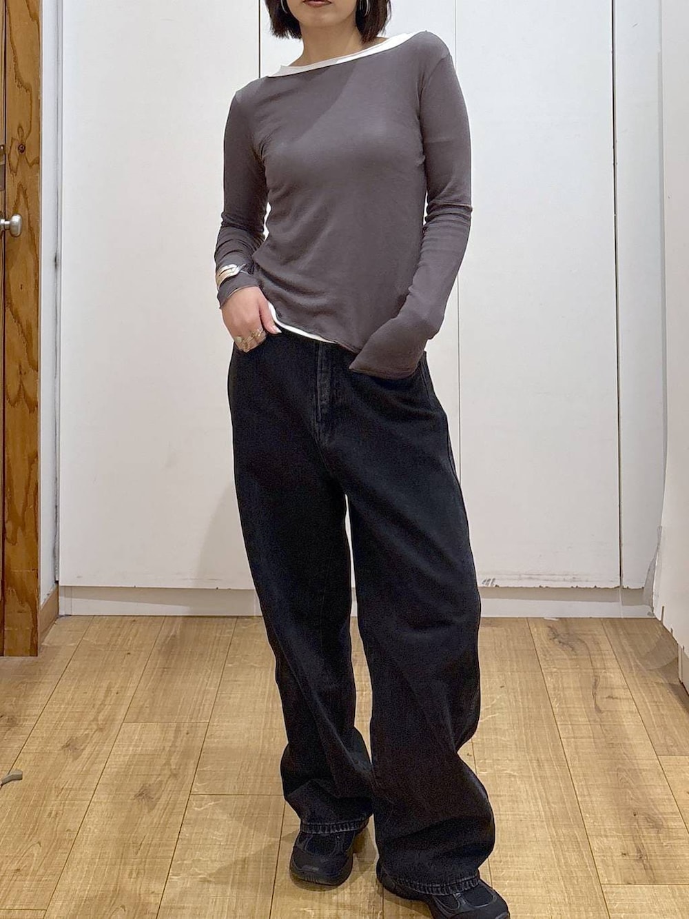 ブラック系のデニムパンツ、ブラック系のスニーカー、ホワイト系のTシャツ/カットソーを着用したレディースの秋コーディネートの5枚目の写真