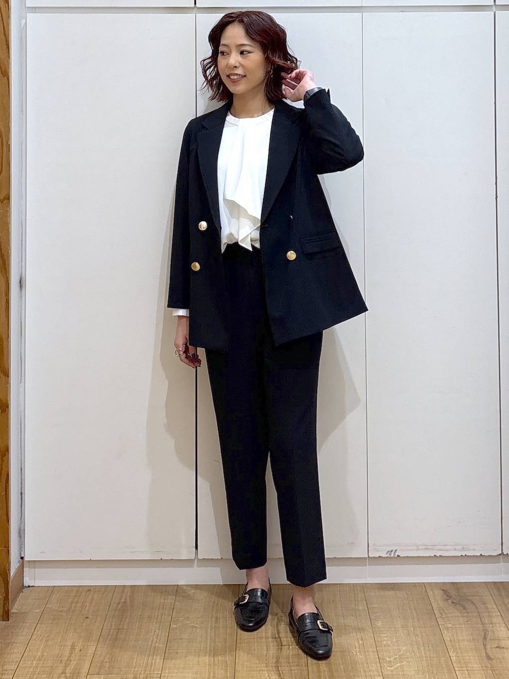 ブラック系のローファー、ブルー系のスラックス、ホワイト系のシャツ/ブラウスを着用したレディースの春コーディネートの3枚目の写真