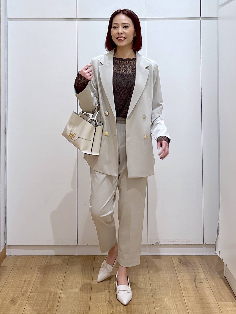 ベージュ系のスラックス、ベージュ系のテーラードジャケット、ベージュ系のショルダーバッグを着用したレディースの春コーディネートの3枚目の写真