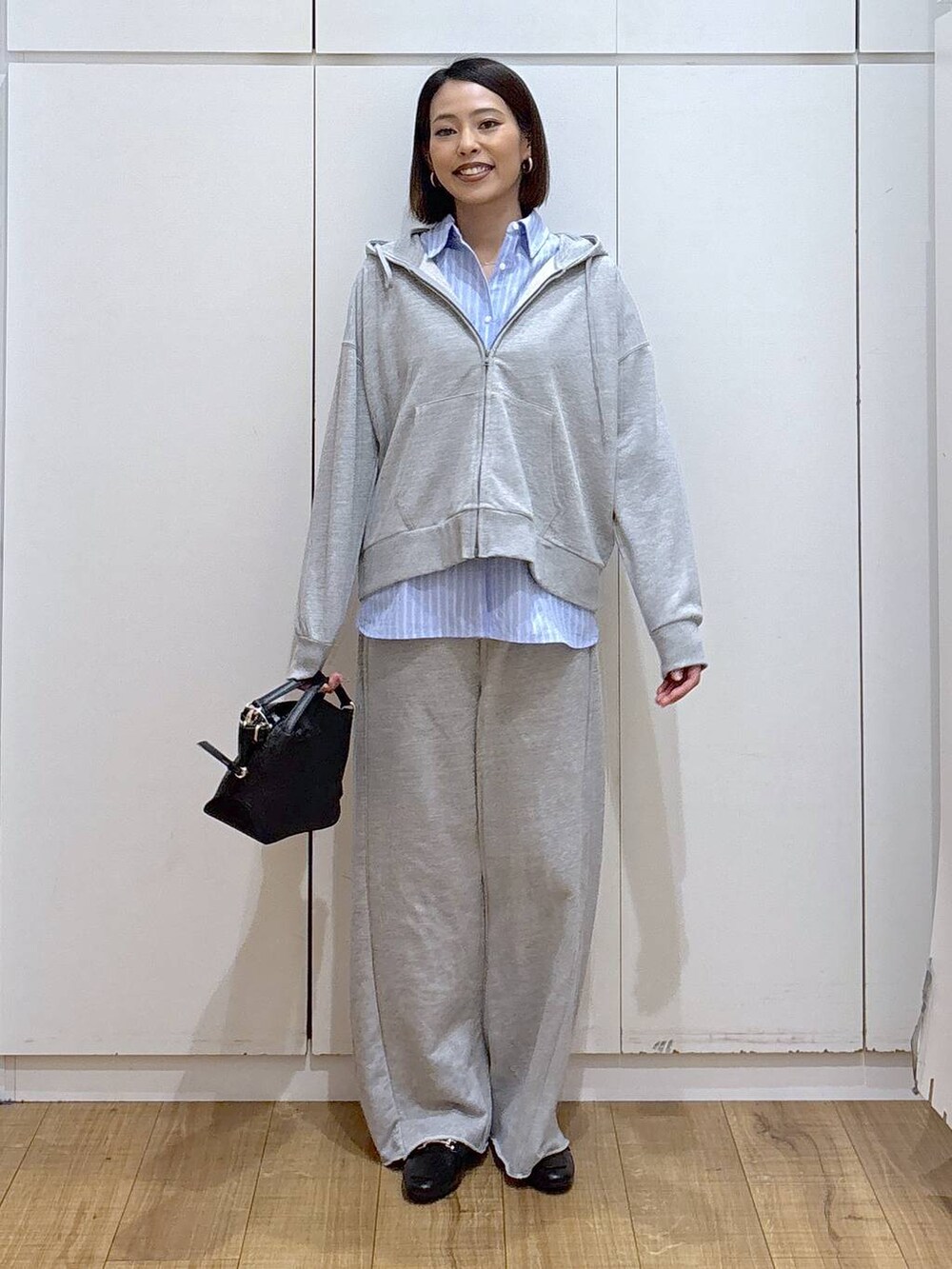 ブラック系のローファー、ブラック系のショルダーバッグ、グレー系のスウェットパンツを着用したレディースの冬コーディネートの4枚目の写真