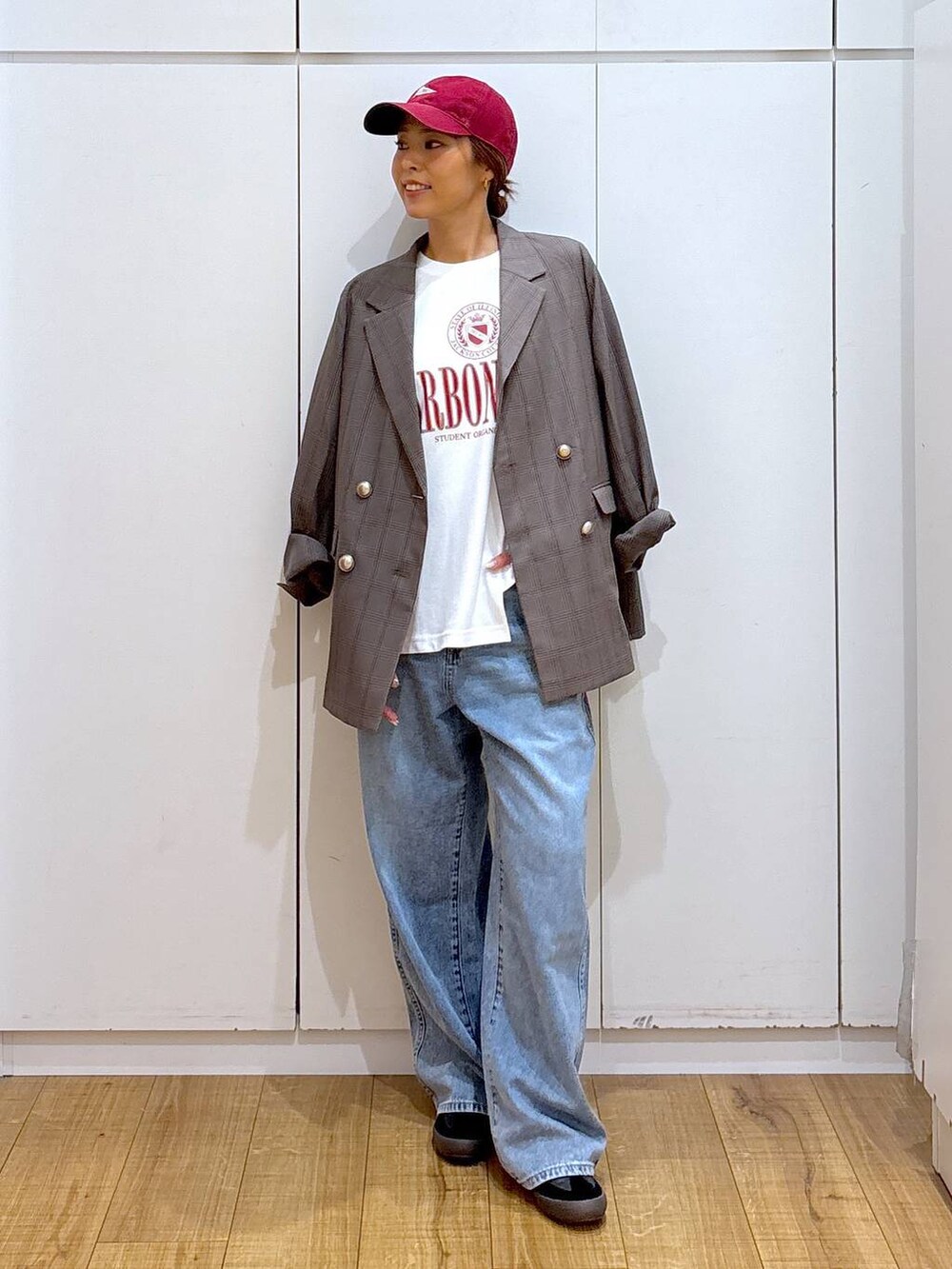 ブラック系のスニーカー、ブラウン系のテーラードジャケット、ブルー系のデニムパンツを着用したレディースの秋コーディネートの4枚目の写真