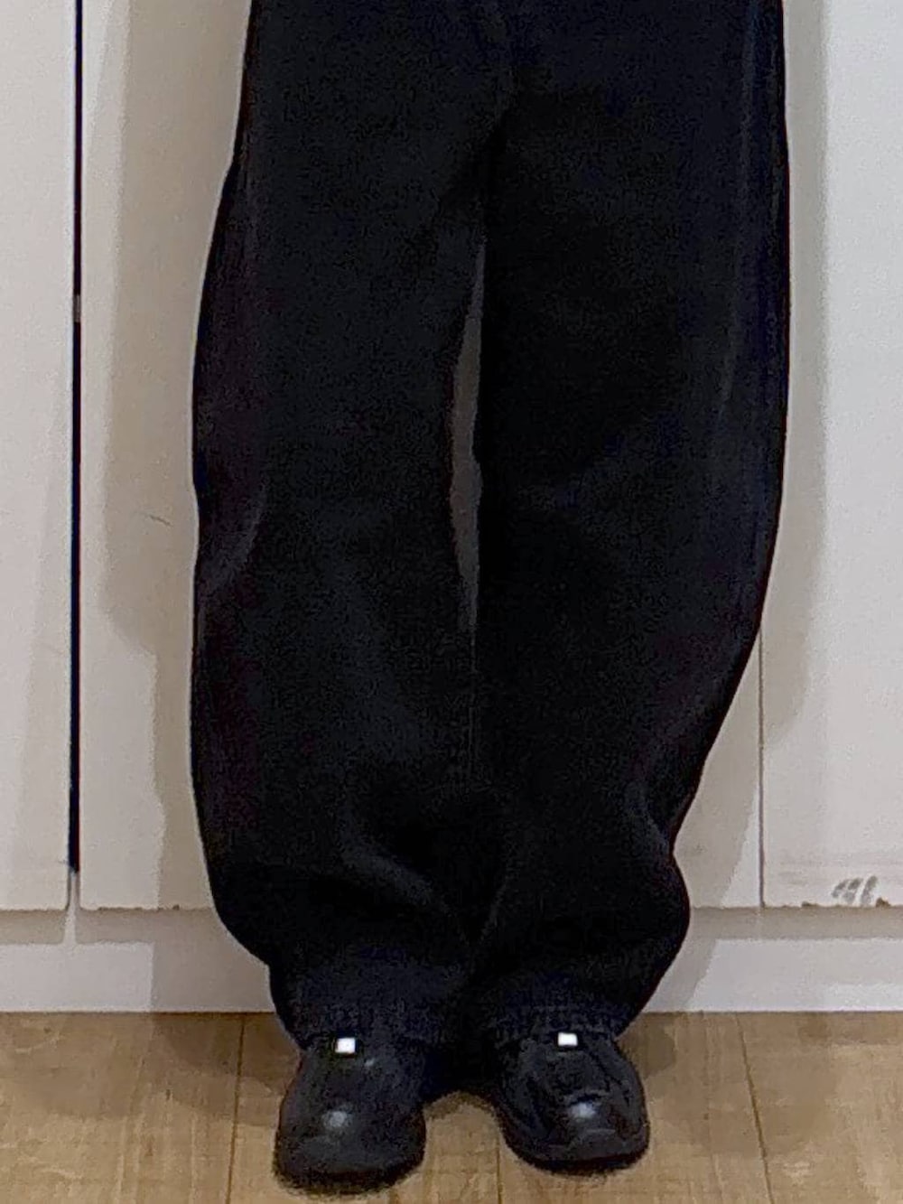 ブラック系のスニーカー、ブラック系のデニムパンツ、グレー系のパーカーを着用したレディースの冬コーディネートの6枚目の写真