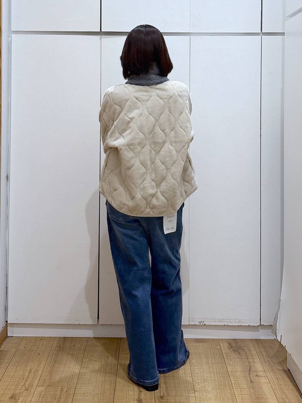 ベージュ系のブルゾン、ブラック系のブーツ、ブルー系のデニムパンツを着用したレディースの秋コーディネートの4枚目の写真