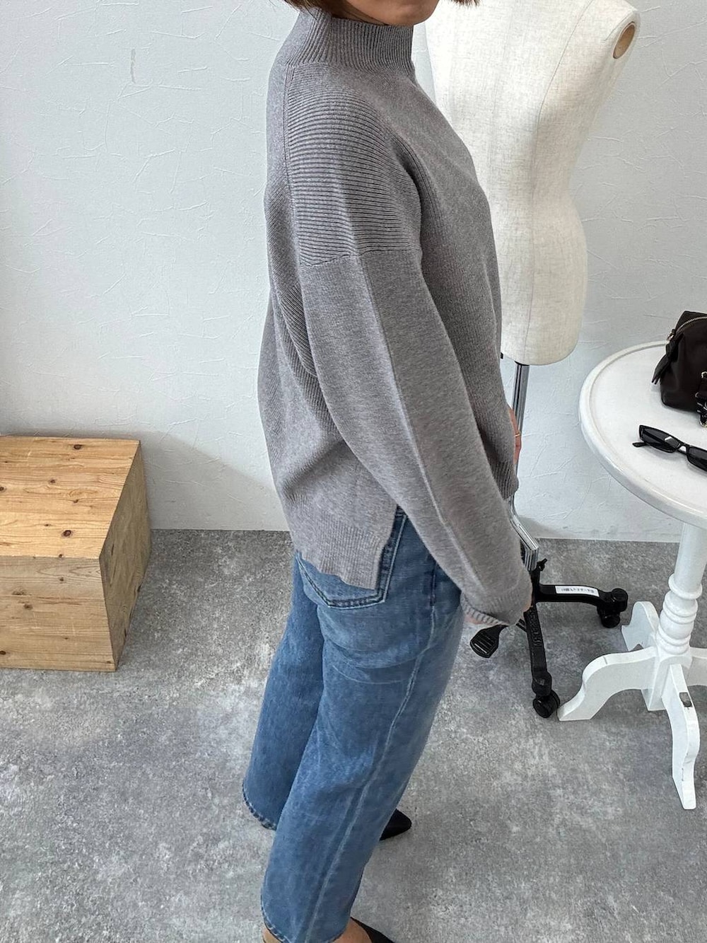 ブラック系のボストンバッグ、ブルー系のデニムパンツ、ブラック系のパンプスを着用したレディースの秋コーディネートの5枚目の写真