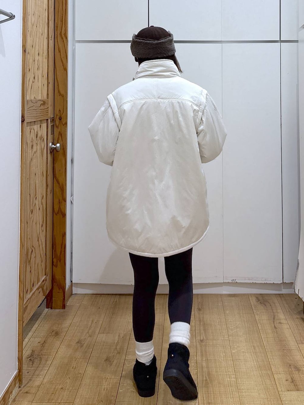 ブラック系のショルダーバッグ、ベージュ系のブルゾン、ホワイト系のTシャツ/カットソーを着用したレディースの冬コーディネートの4枚目の写真