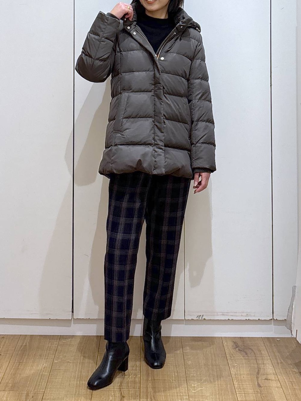 ブラウン系のダウンジャケット/コート、ブラック系のニット/セーター、ブルー系のその他パンツを着用したレディースの秋コーディネートの5枚目の写真