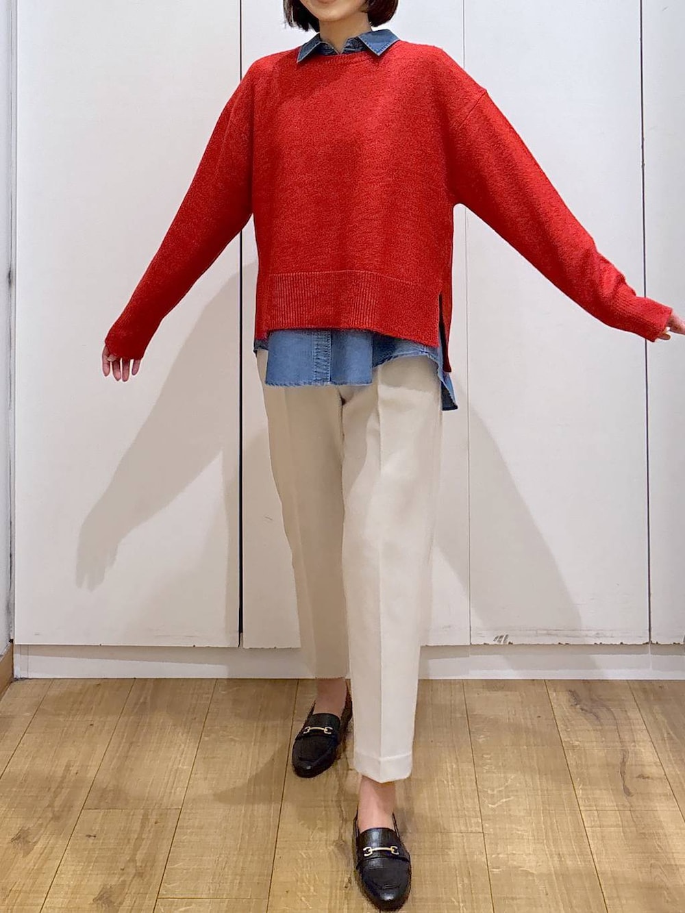 ブラック系のローファー、ブルー系のシャツ/ブラウス、レッド系のニット/セーターを着用したレディースの冬コーディネートの3枚目の写真