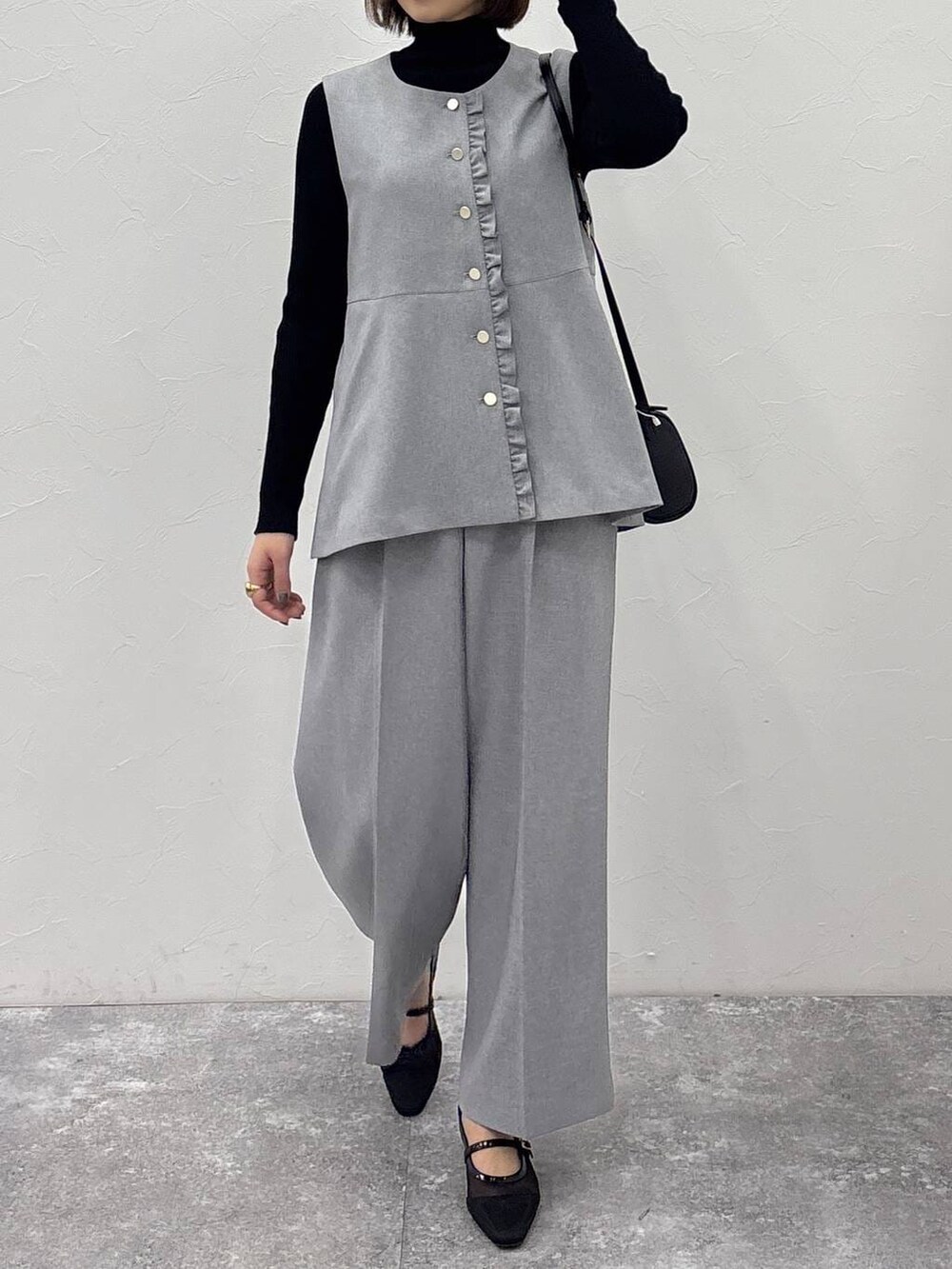 ブラック系のニット/セーター、グレー系のその他パンツ、グレー系のベストを着用したレディースの冬コーディネートの3枚目の写真