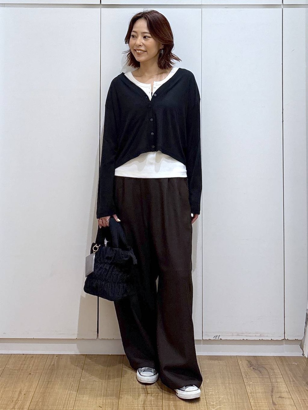 ブラウン系のその他パンツ、ホワイト系のタンクトップ、ブラック系のカーディガン/ボレロを着用したレディースの春コーディネートの3枚目の写真