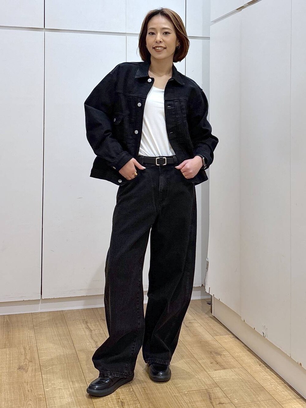 ブラック系のデニムパンツ、ブラック系のデニムジャケット、ホワイト系のキャミソールを着用したレディースの春コーディネートの2枚目の写真