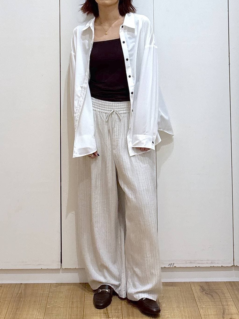 ブラウン系のローファー、ホワイト系のシャツ/ブラウス、ベージュ系のその他パンツを着用したレディースの春コーディネートの2枚目の写真