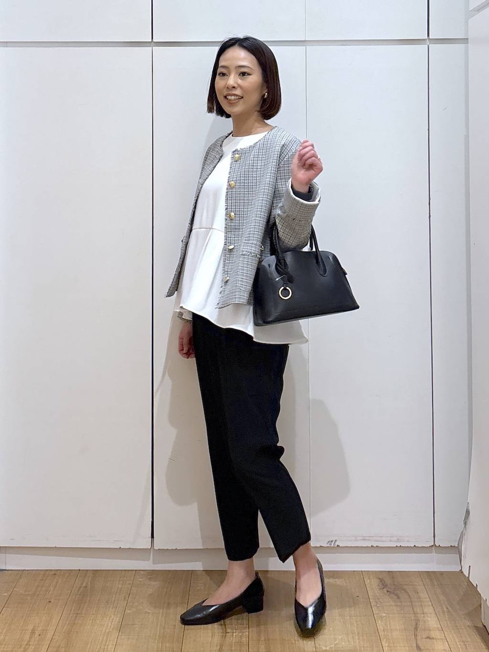 ブラック系のショルダーバッグ、ブラック系のパンプス、ブラック系のスラックスを着用したレディースの冬コーディネートの3枚目の写真