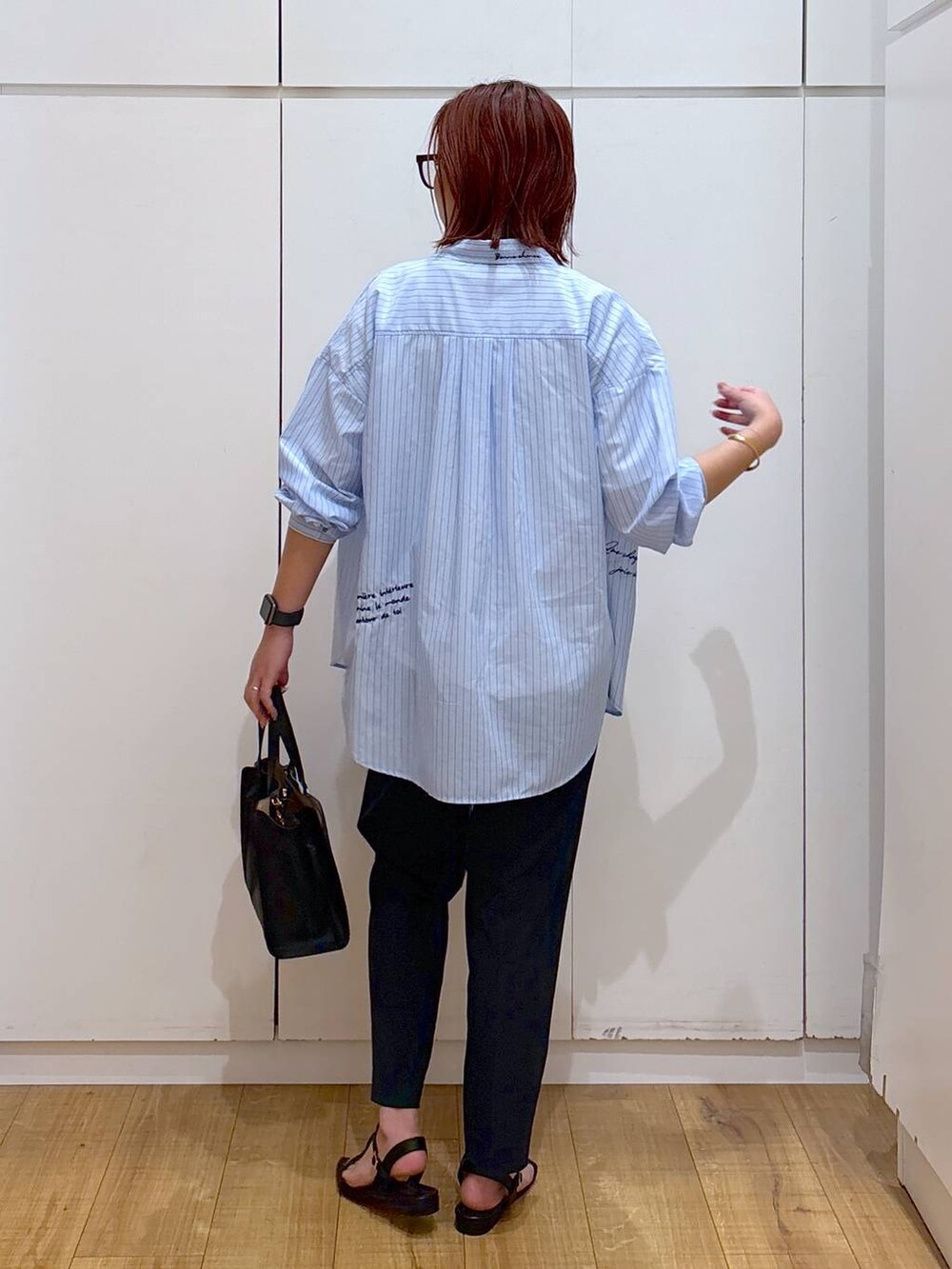 ホワイト系のTシャツ/カットソー、ブラック系のサンダル、ブラック系のショルダーバッグを着用したレディースの夏コーディネートの4枚目の写真