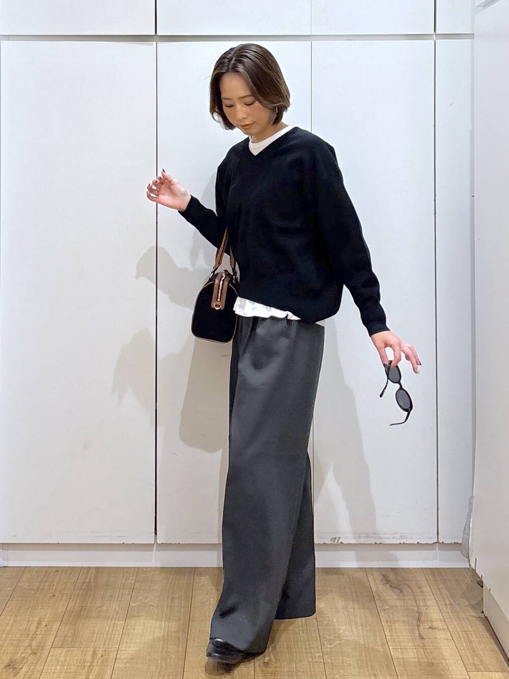 ブラック系のローファー、ブラック系のスウェット、グレー系のその他パンツを着用したレディースの秋コーディネートの5枚目の写真