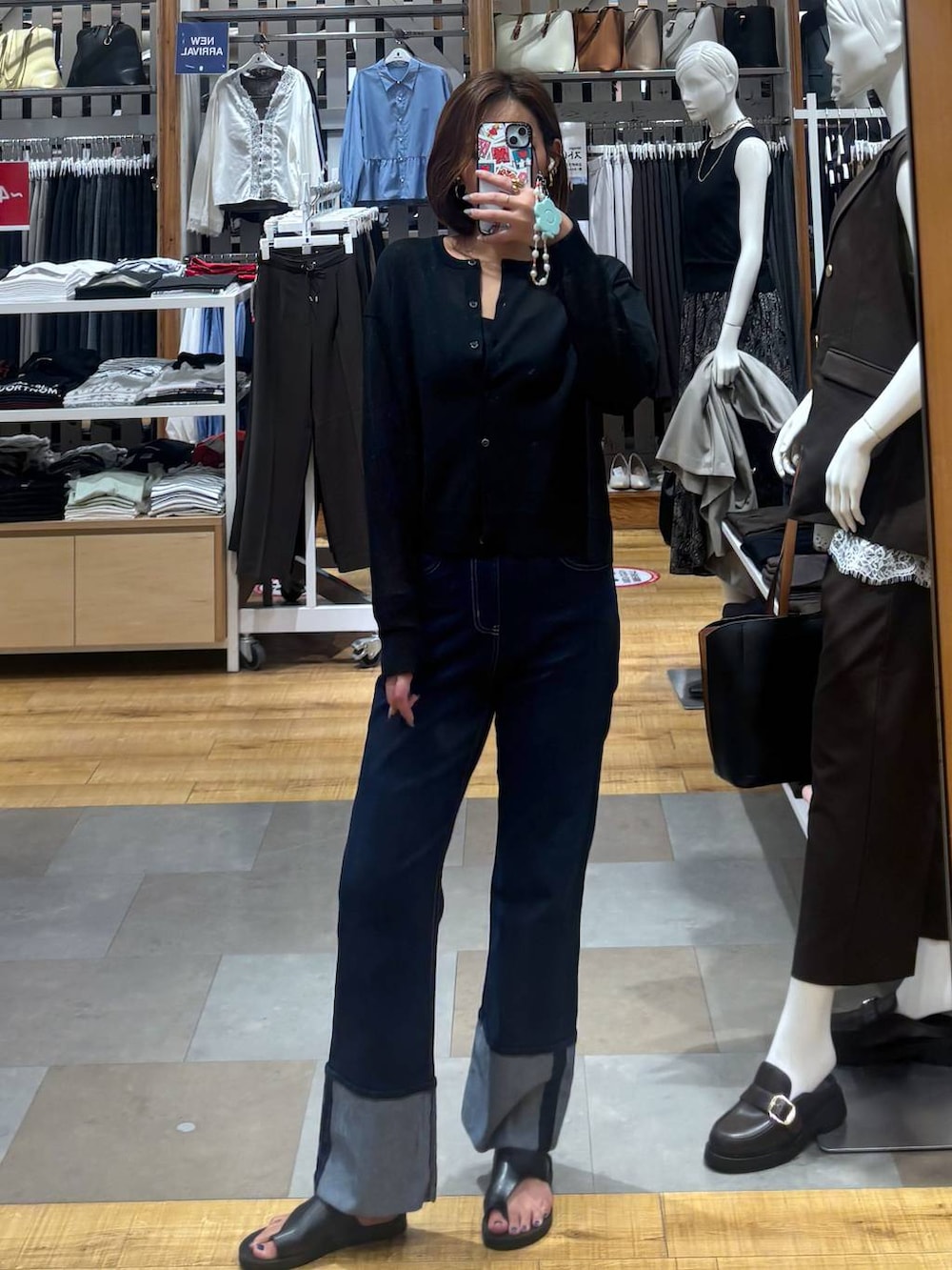 ブルー系のデニムパンツ、ブラック系のキャミソール、ブラック系のカーディガン/ボレロを着用したレディースの夏コーディネートの4枚目の写真