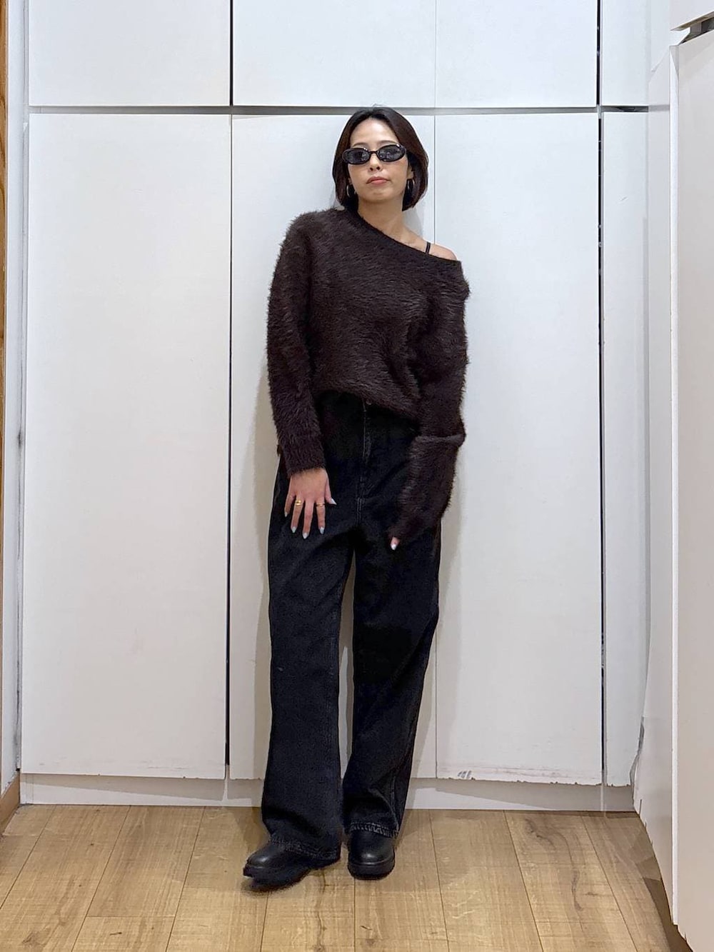 ブラック系のデニムパンツ、ブラック系のブーツ、ブラウン系のニット/セーターを着用したレディースの冬コーディネートの3枚目の写真